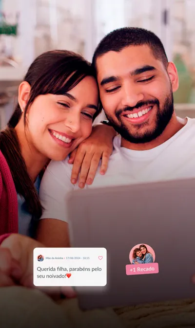 Visualização de Mural de Recados no Celular - Casar.com Imagem de um casal sorridente abraçados e sentados no sofá olhando o tablet com depoimentos dos seus convidados